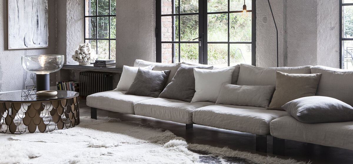 Individuell gepolstertes Sofa in hellem Leinenstoff in einem Loft-Wohnzimmer