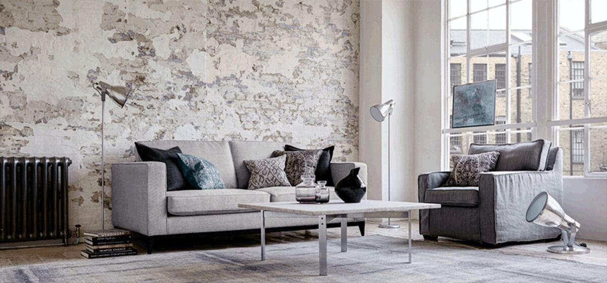 Individuell bezogenes Sofa in einem Loft mit freigelegter Ziegelwand